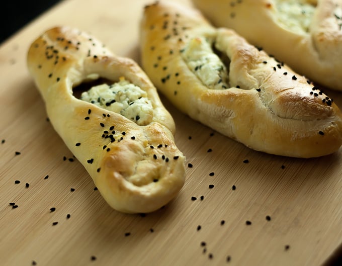 Lebanese cheese fatayer with black sesame seeds on a wooden cutting board