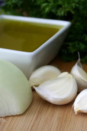 A photo of chimi churri ingredients on a wooden cutting board.