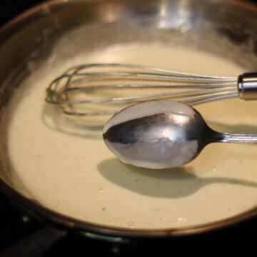 A photo of a spoon with a sauce that is wiped for checking nappe consistency.