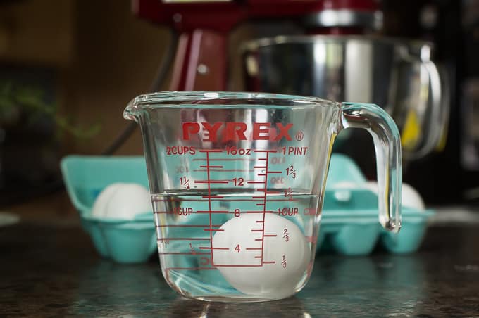 a pyrex container with water and an egg inside 
