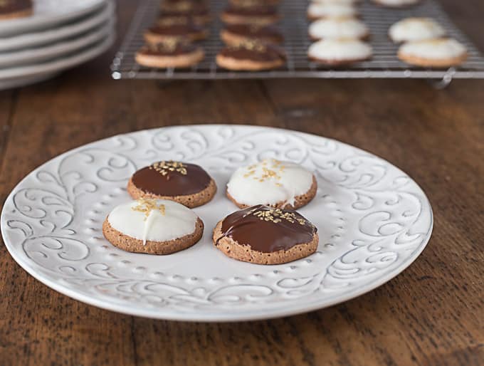 four lebkuchen on a white plate topped with chocolate 