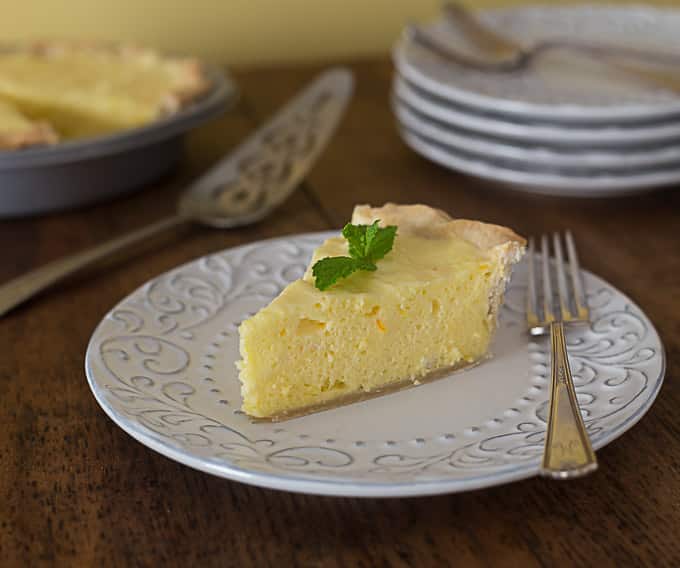 light and fluffy orange lemon pie on a white plate with a fork