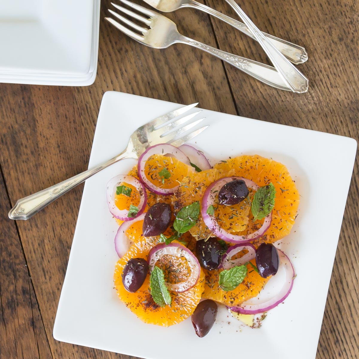 A photo of Turkish orange and onion salad or portakal salatsi on a white plate.