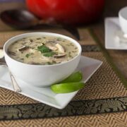 Thai coconut chicken soup with limes on a bamboo placemat