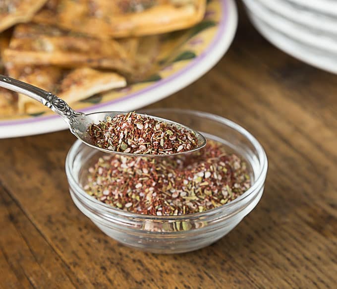 a spoon with zatar and a bowl of zatar
