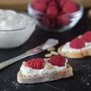 Crostini with fresh homemade ricotta cheese, pine nuts and raspberries.