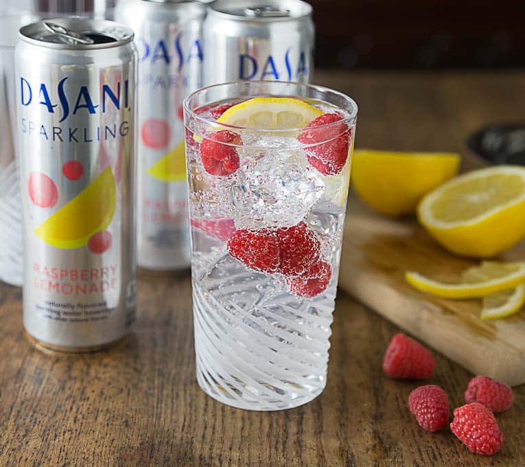 cans of sparkling water and a glass of mocktail with fruit