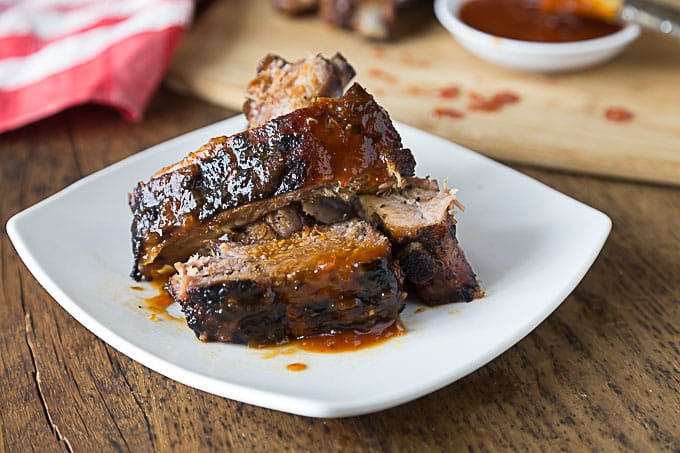 a plate of grilled ribs with bbq sweet and spicy bbq sauce 