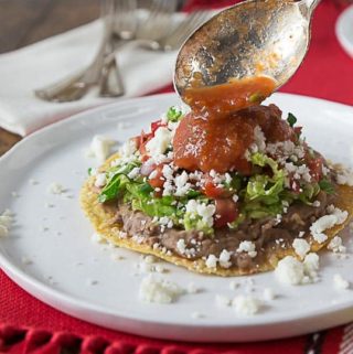 tostada on a white plate with cheese