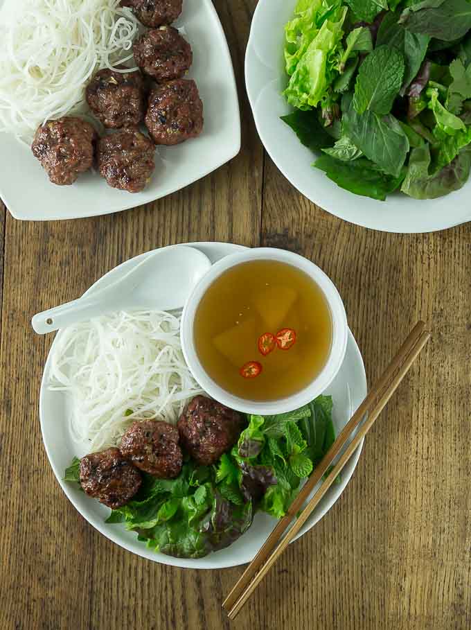 plates of meatballs, greens, noodles and broth