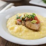 Tender and delicious roasted garlic and herb pork loin with cheesy grits, avocado and pico de gallo. Latin fusion meets Southern cuisine. Serve this tasty pork over grits with some spicy pico and you will love the flavors! | ethnicspoon.com