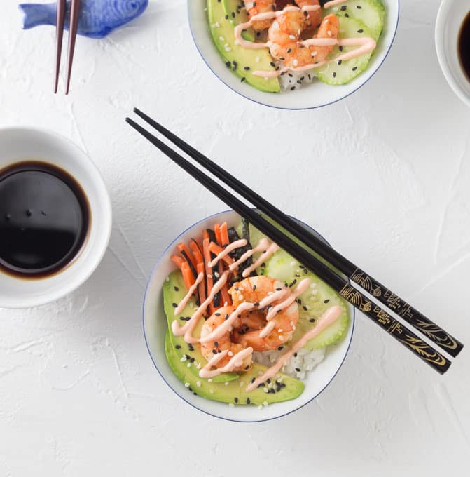 two sushi bowls with chopsticks and a bowl of soy sauce 