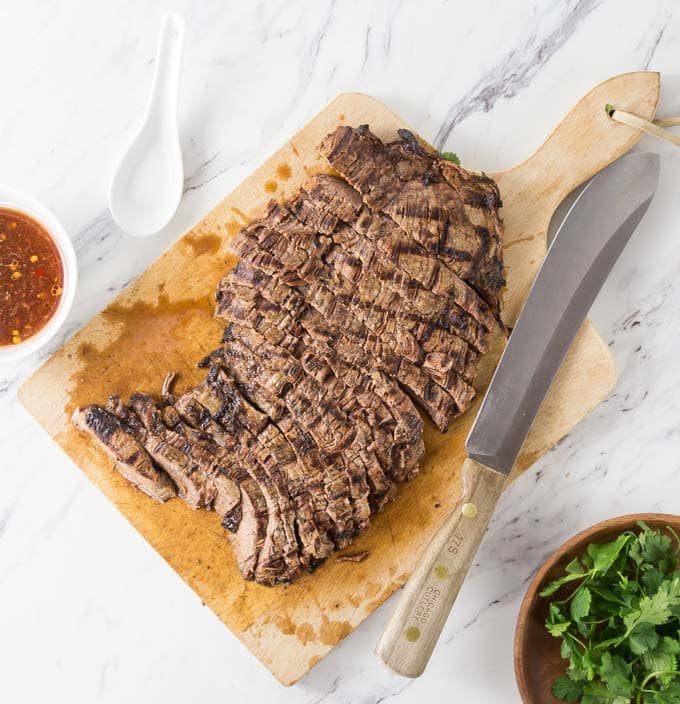 a large steak on a cutting board grilled and cut