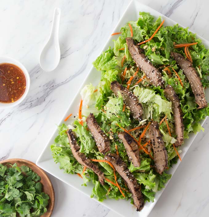 Try an exotic recipe for the grill this summer! You will love the spicy flavors in this recipe. Thai beef salad with the exotic flavors of lemongrass, tamarind, spicy chili garlic sauce and palm sugar make for a spectacular flavor profile and so easy to make. I love to use flank steak and cut it on the bias into strips for my salad. | ethnicspoon.com
