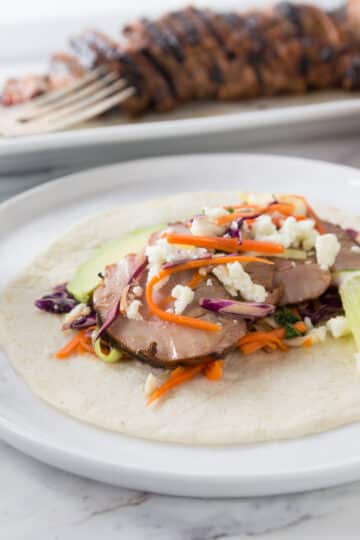 A photo of a pork loin taco with cabbage slaw.