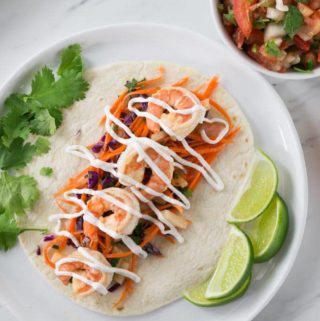 You are going to love these spicy shrimp tacos with jicama slaw. This recipe comes together very quick so it's a must try for a fast weeknight meal too! The jicama (hee cah ma) slaw has carrot sticks, and red cabbage. It rocks! It's colorful to say the least. It's a perfect complement to the soft shrimp. | ethnicspoon.com