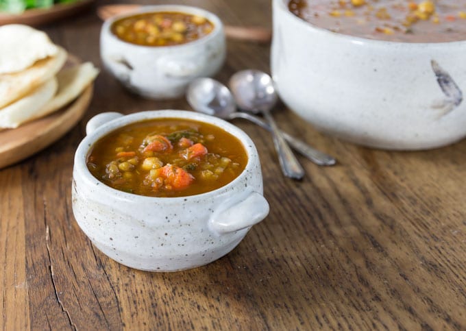 two bowls and a pot of moroccan lentil soup 