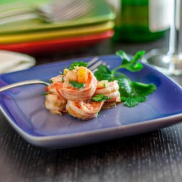 A photo of Spanish style shrimp on a blue plate.