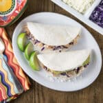 An overhead photo of chicken tinga tacos on a white plate.