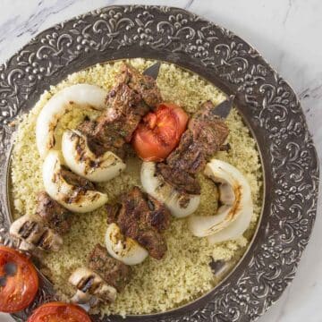 Moroccan spiced beef kababs on a bed of couscous.