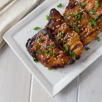 A photo of Korean BBQ pork chops on a white plate