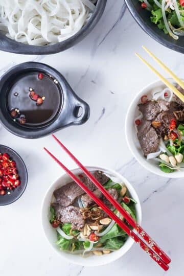 A photo of Vietnamese pho tron in a white bowl with chop sticks.