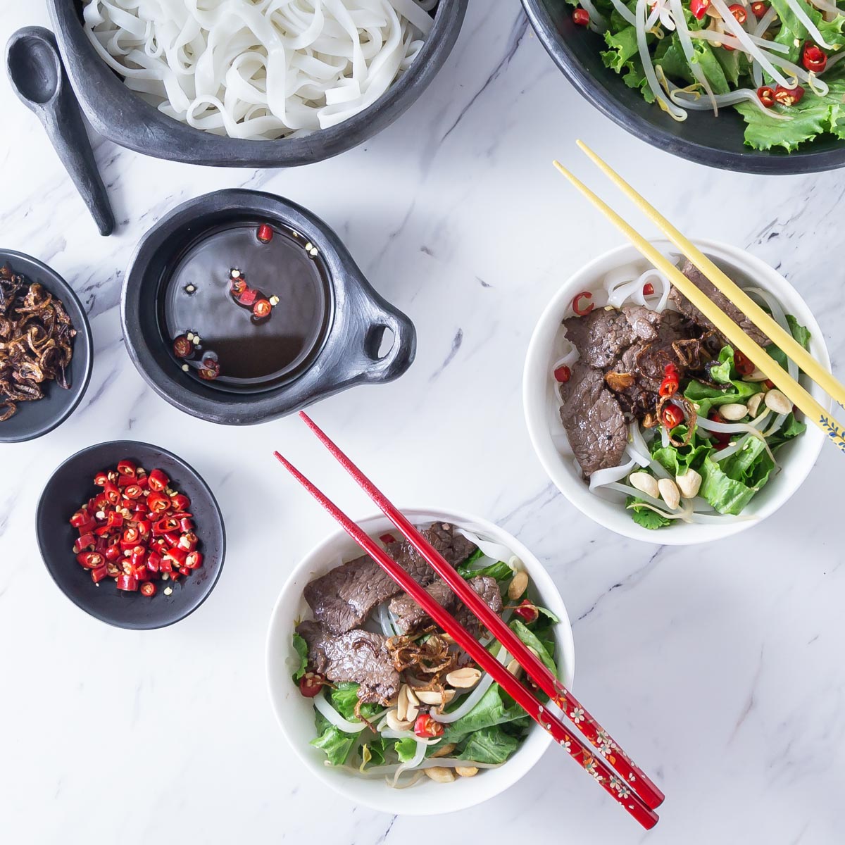 A photo of Vietnamese pho tron in a white bowl with chop sticks.