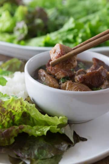 A photo of Vietnamese braised coconut pork, thit kho tau, in a white bowl.
