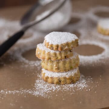 A photo of pistachio rosewater cookies with powdered sugar.