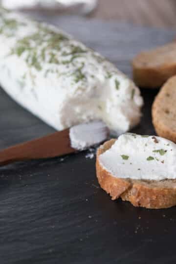 A photo of goat cheese on a cutting board with sliced baguette.
