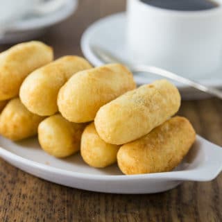 A photo of carimañolas on a white plate.