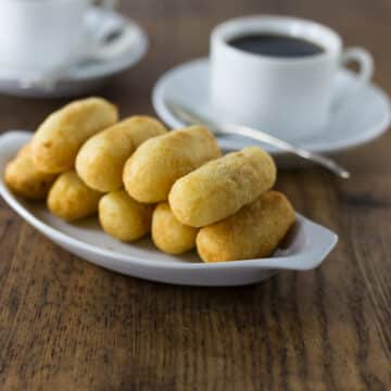 A photo of carimañolas on a white platter.
