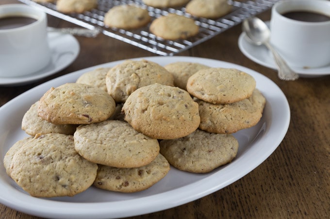 A plate of hermit cookies on a plate with a cooling rack in the background.