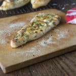A photo of Turkish pide on a wooden cutting board.