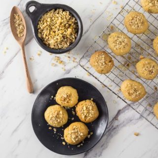 An overhead shot of Greek melomakarona cookies on a black plate.