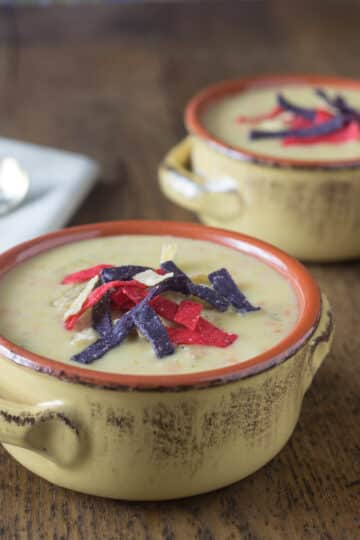 A photo of turkey burger soup in a ceramic bowl with spoons in the background.