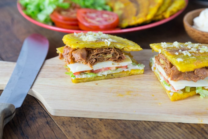 A jibarito sandwich cut in half in a side view photo.