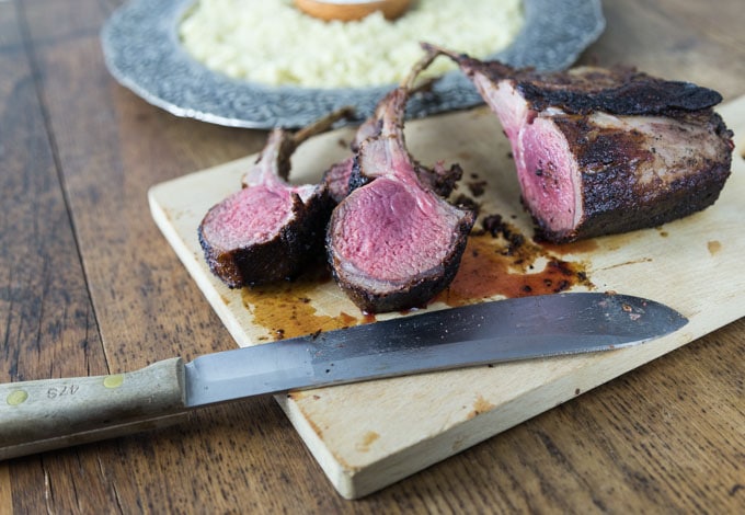 Turkish style rack of lamb on a cutting board with a knife and sliced chops.