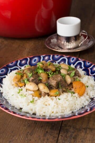 A photo of Turkish lamb stew on a blue plate with rice.