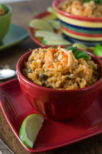 A photo of shrimp asopao in a red bowl.