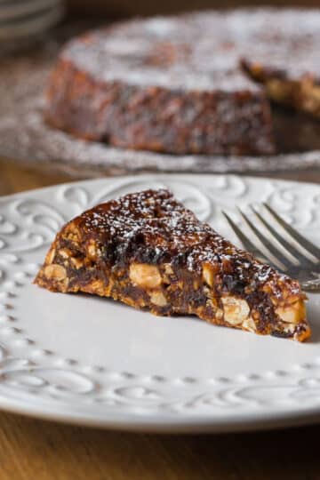 A photo of Italian panforte on a white plate with a fork.