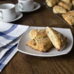 A photo of feta walnut scones on a white plate with a blue and white towel in the background.