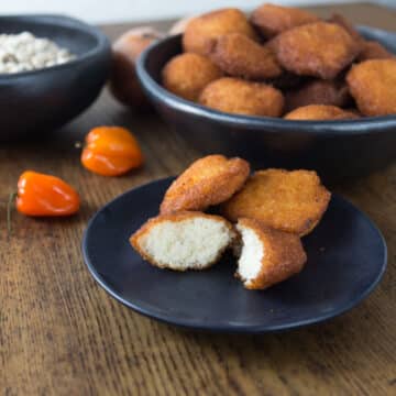 A photo of African akara fritters on a black plate.