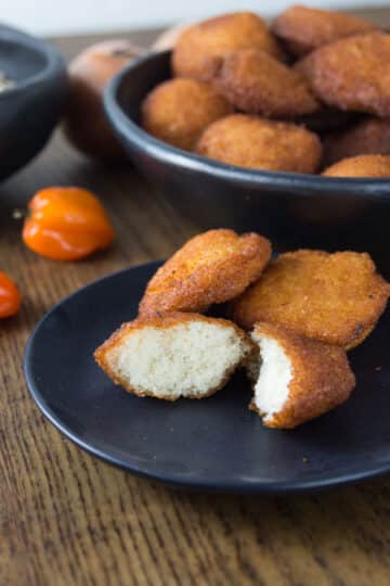 A photo of African akara fritters on a black plate.