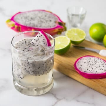 A photo of a dragonfruit lemongrass cocktail in a glass with ice.