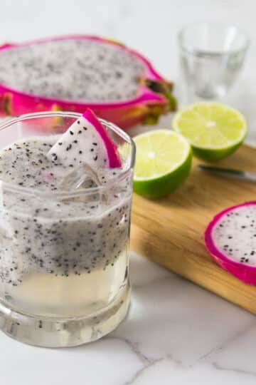 A photo of a dragonfruit lemongrass cocktail in a glass with ice.