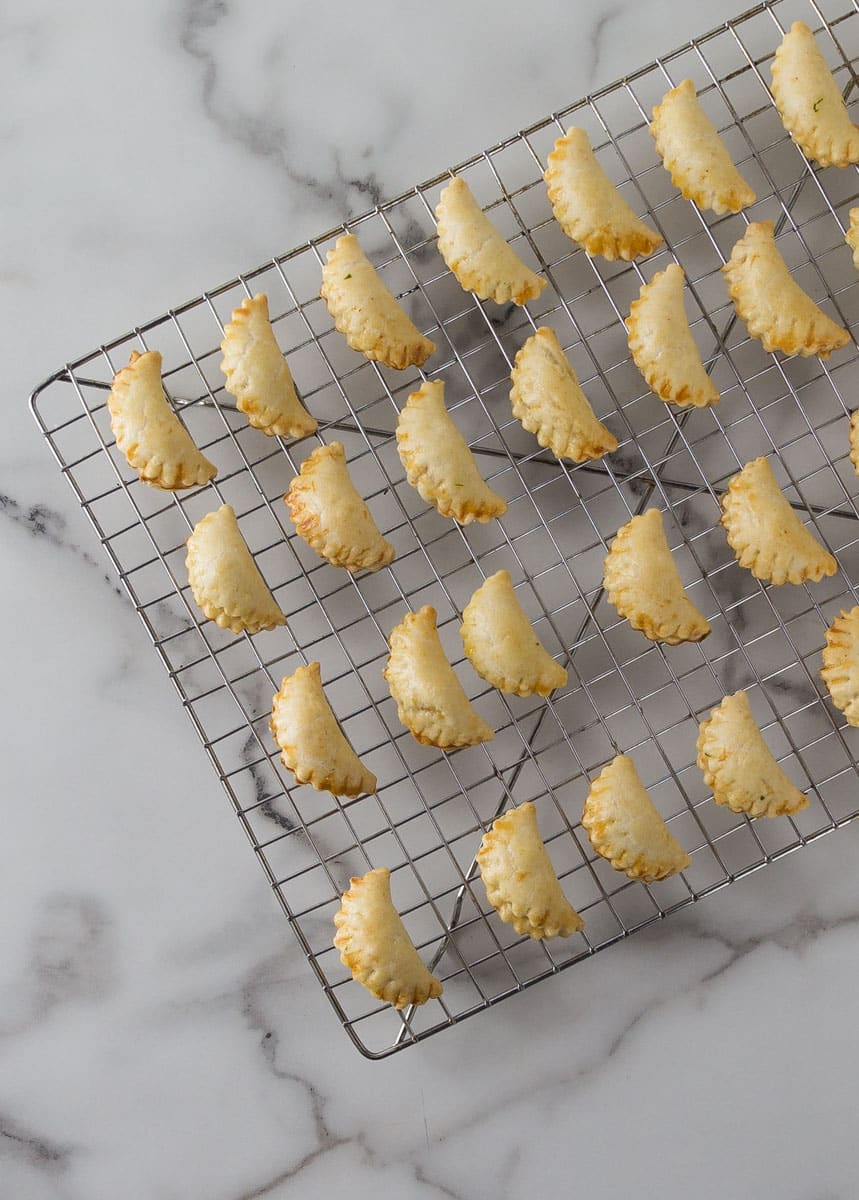 An overhead photo of mini crab meat empanadas in a cooling rack.