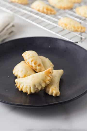 A photo of mini crab meat empanadas in black plate.