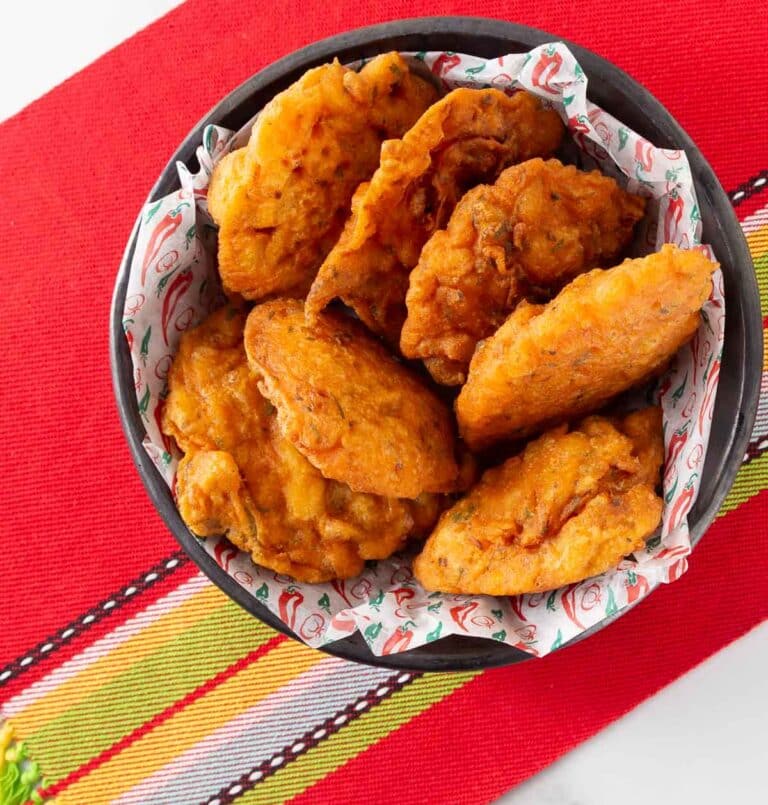 Crispy Puerto Rican bacalaitos codfish fritters in a black ceramic bowl