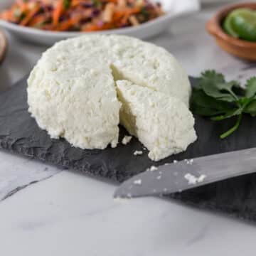 A photo of fresh homemade queso fresco on a slate cheese board.